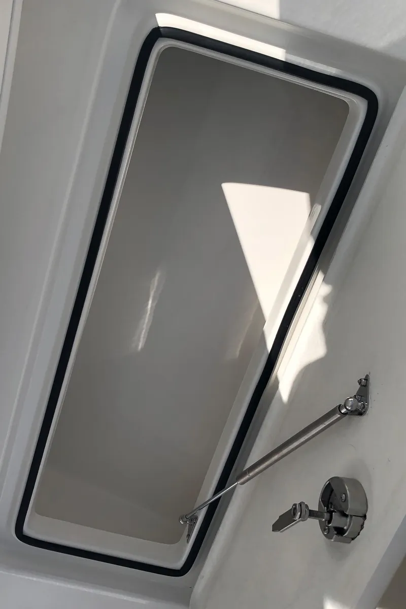 Slide: The Image of 2026 Pair Customs 24 Center Console DV boat hatch interior with latch mechanism. - 32