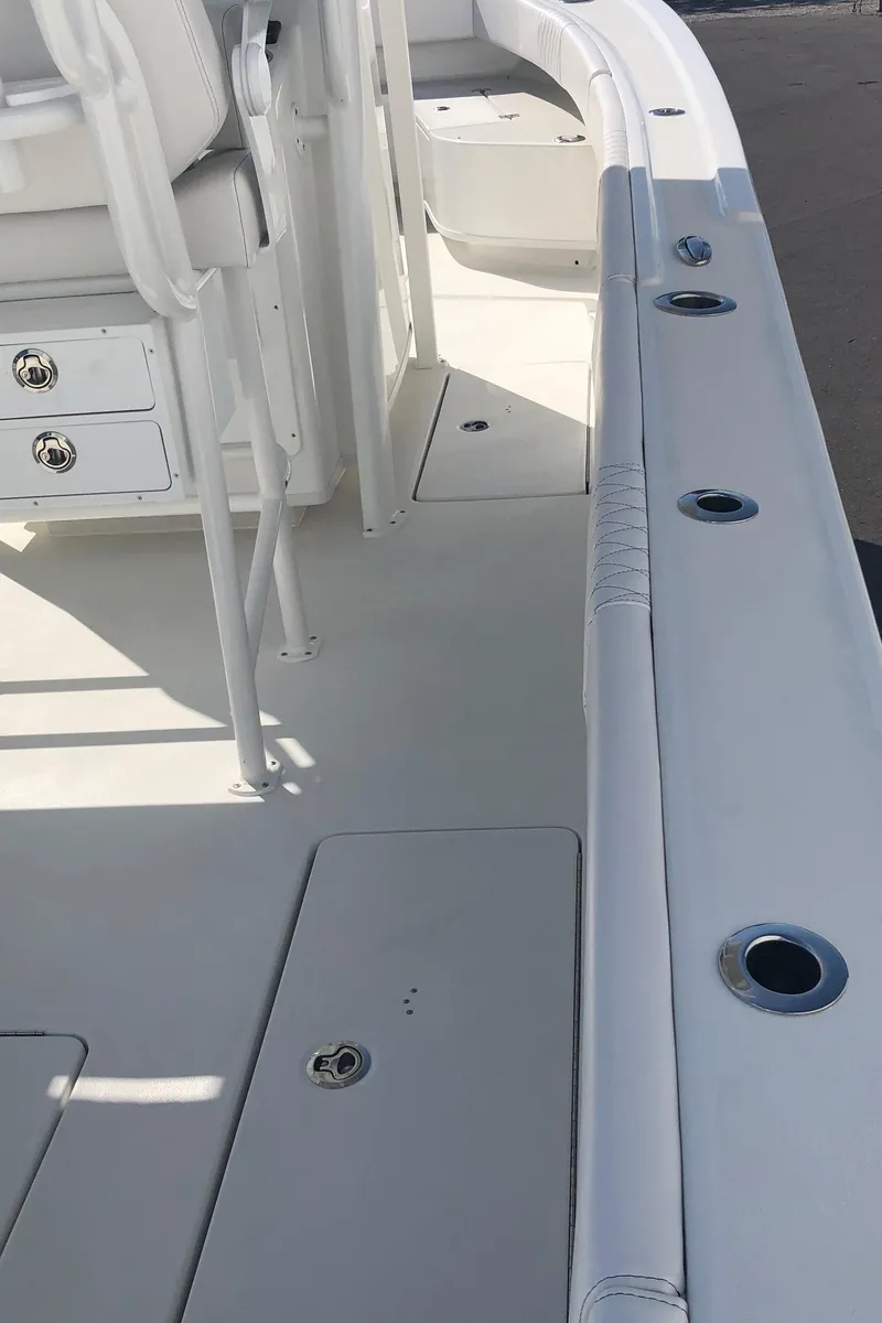 Slide: The Image of 2026 Pair Customs 24 Center Console DV boat interior with white seating and storage compartments. - 43