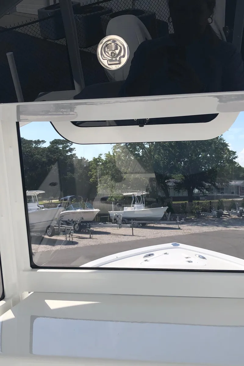 Slide: The Image of 2026 Pair Customs 24 Center Console DV boat, docked with other boats in the background. - 44