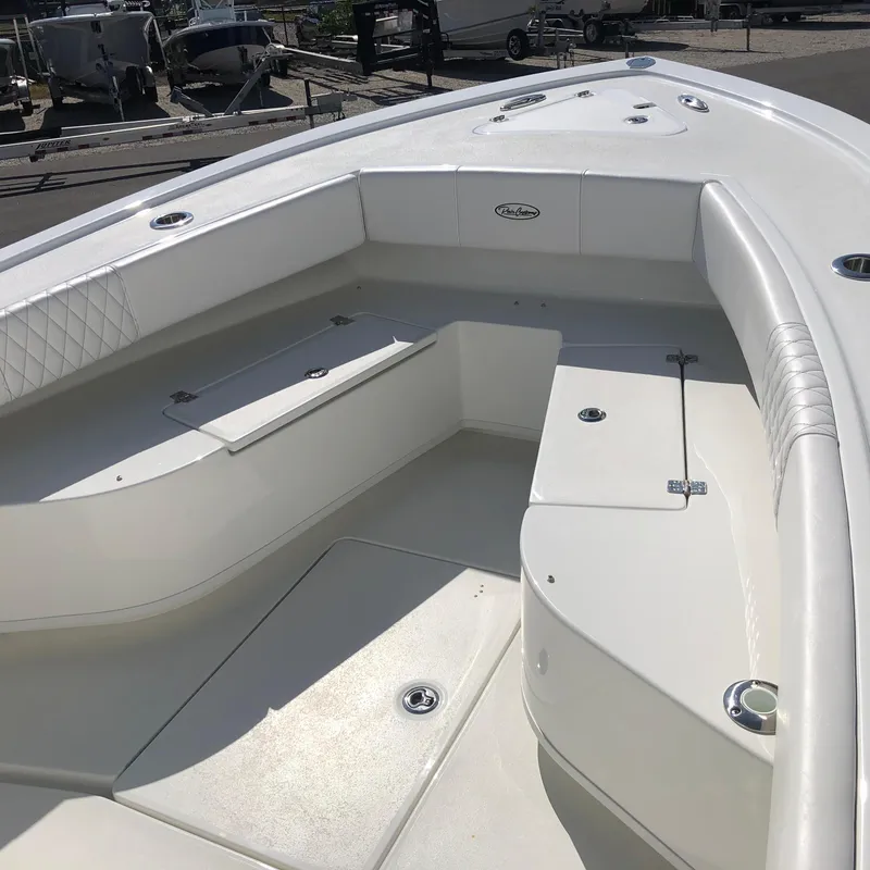 Slide: The Image of 2026 Pair Customs 24 Center Console DV boat interior with white seating and storage compartments. - 6