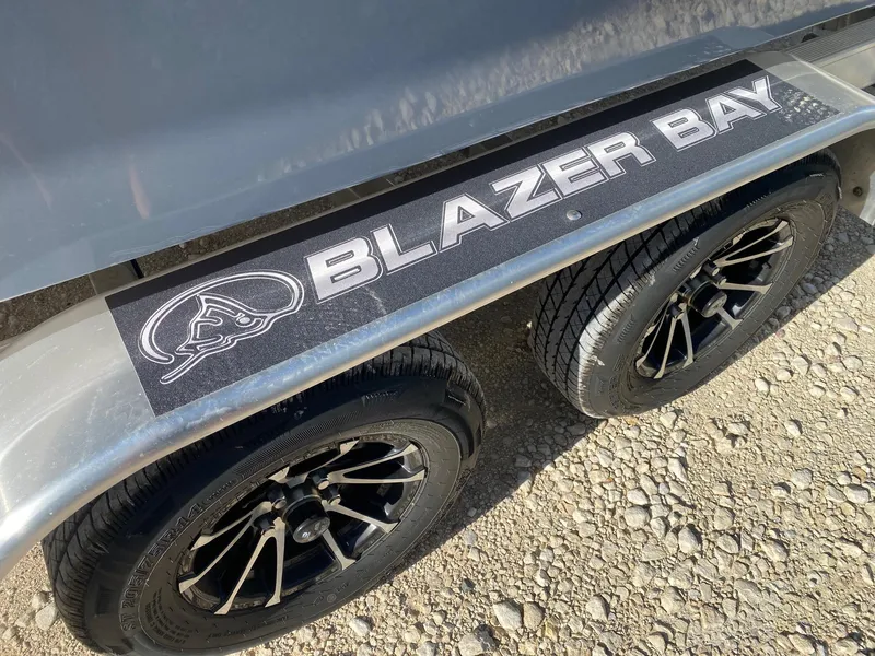 Slide: The Image of 2025 Blazer Bay 2400 Open Bay Striper trailer with logo and dual wheels. - 11