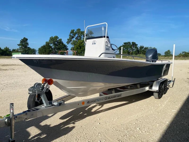 Slide: The Image of 2025 Blazer Bay 2400 Open Bay Striper boat on trailer, parked outdoors. - 2