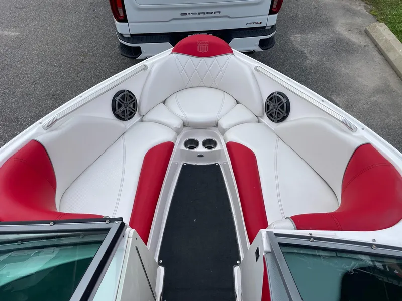 Slide: The Image of 2013 MasterCraft X-14V boat interior with red and white seating, speakers, and cup holders. - 2