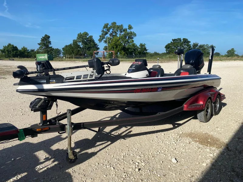 Slide: The Image of 2012 Skeeter FX 20 boat on trailer, parked outdoors on gravel. - 2