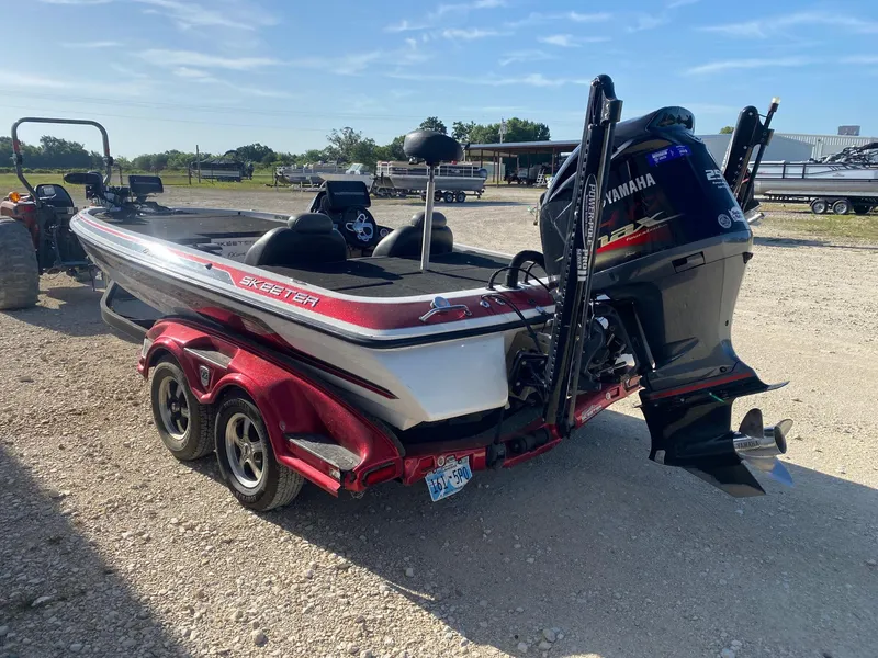 Slide: The Image of 2012 Skeeter FX 20 boat with Yamaha engine on a trailer, parked outdoors. - 3