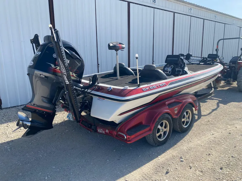 Slide: The Image of 2012 Skeeter FX 20 boat with Yamaha motor, parked on a trailer in a storage area. - 5