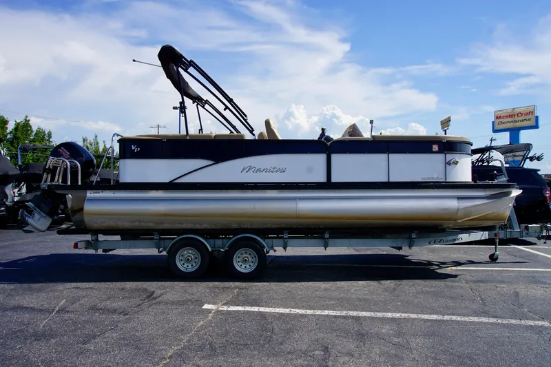 Slide: The Image of 2022 Manitou 23 Aurora LE RF pontoon boat on trailer in parking lot. - 1