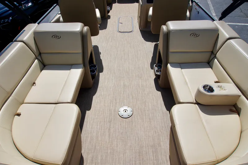 Slide: The Image of 2022 Manitou 23 Aurora LE RF boat interior with beige seating and cup holders. - 11