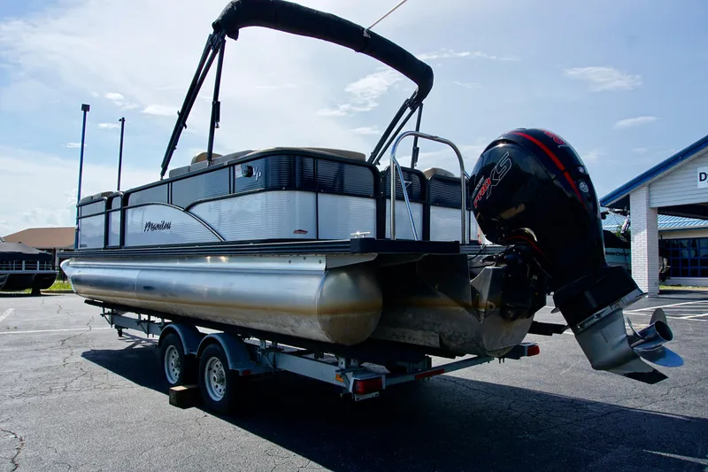 Slide: The Image of 2022 Manitou 23 Aurora LE RF pontoon boat on trailer, parked outdoors. - 2