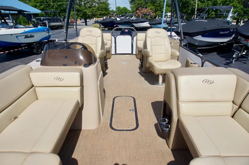 Slide: The Image of 2022 Manitou 23 Aurora LE RF pontoon boat interior with beige seating and helm. - 6