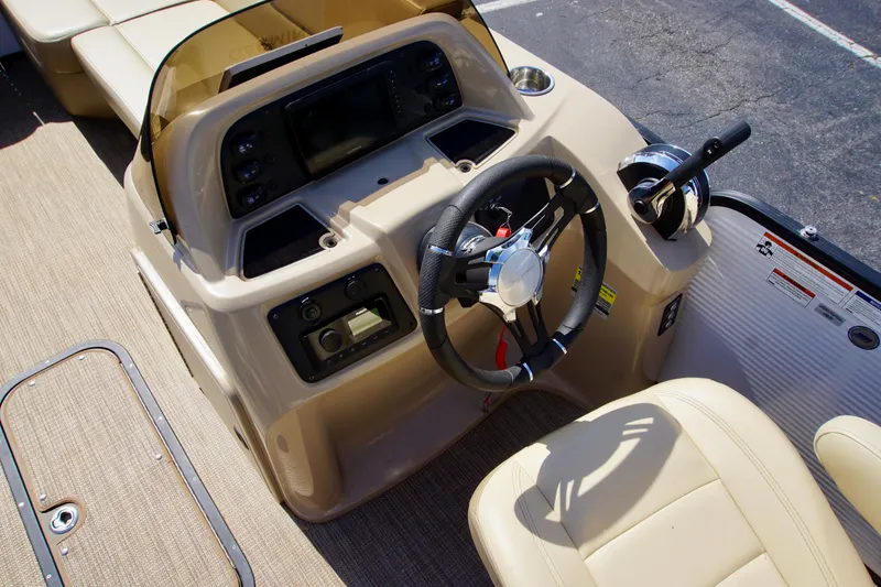 Slide: The Image of 2022 Manitou 23 Aurora LE RF boat dashboard with steering wheel and controls. - 8