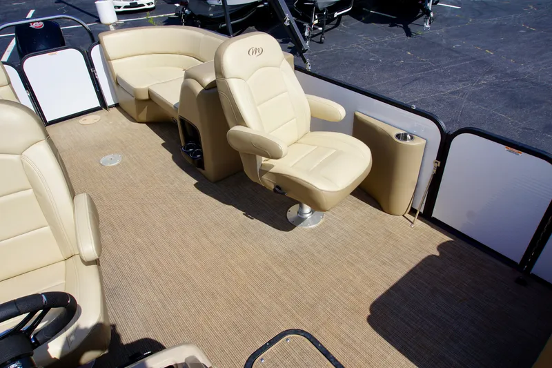 Slide: The Image of 2022 Manitou 23 Aurora LE RF boat interior with beige seating and carpeted floor. - 9