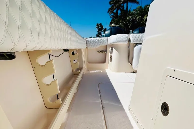 Slide: The Image of 2012 Grady-White Canyon 366 boat interior with rod holders and cushioned seating. - 18