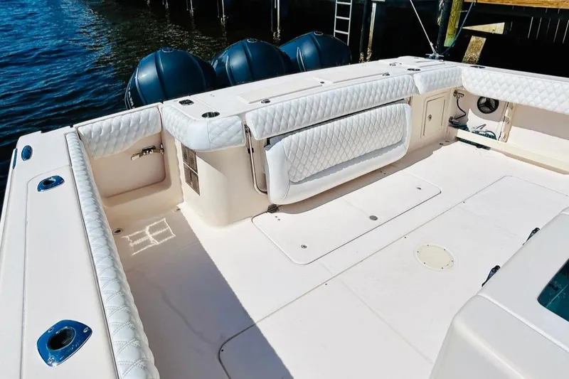 Slide: The Image of 2012 Grady-White Canyon 366 boat deck with cushioned seating and triple outboard motors. - 8