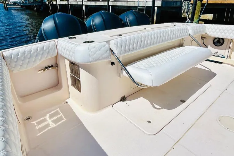 Slide: The Image of 2012 Grady-White Canyon 366 boat with white cushioned seating and triple outboard motors. - 9