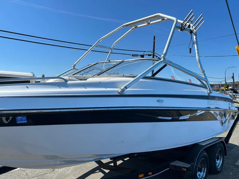 Slide: The Image of 2007 Reinell 220 LSE boat on trailer, featuring sleek design and wakeboard tower. - 1