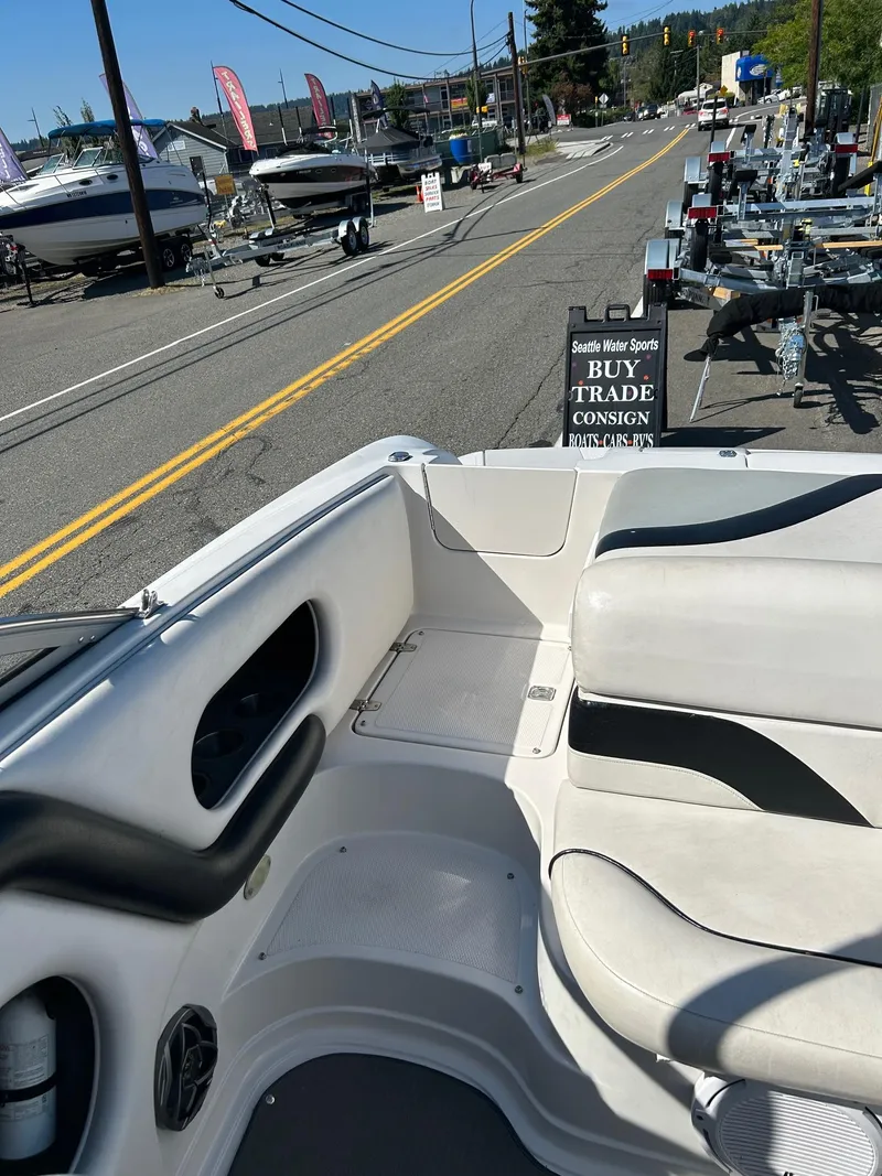 Slide: The Image of 2007 Reinell 220 LSE boat interior at a dealership with trailers and signage. - 11