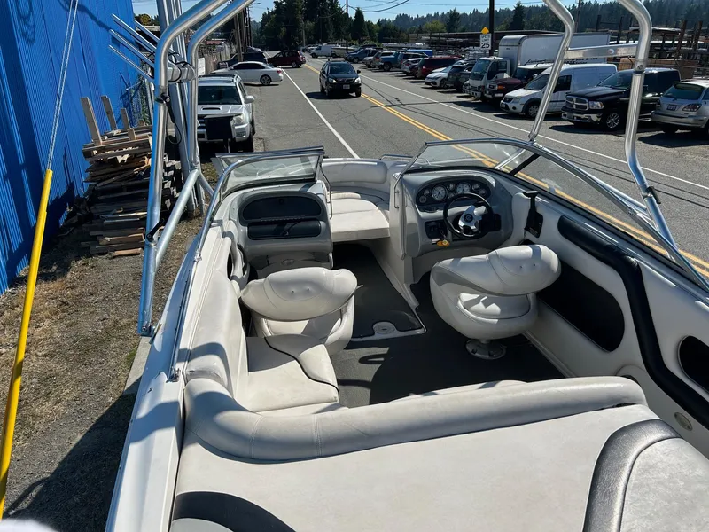 Slide: The Image of 2007 Reinell 220 LSE boat interior with seating and steering wheel, parked near a road. - 13