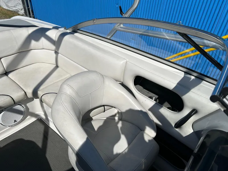 Slide: The Image of 2007 Reinell 220 LSE boat interior with white seating and blue exterior backdrop. - 14