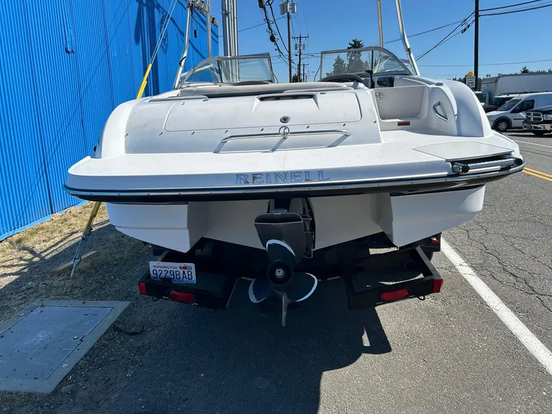 Slide: The Image of 2007 Reinell 220 LSE boat, rear view, parked on a trailer near a blue wall. - 2