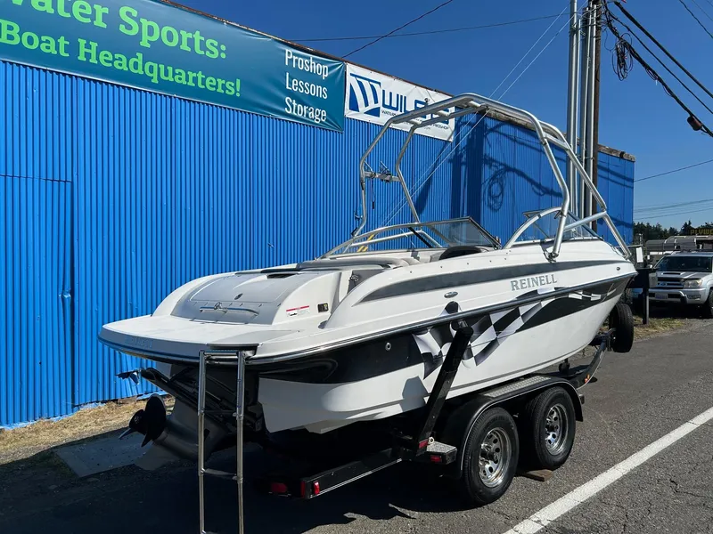 Slide: The Image of 2007 Reinell 220 LSE boat on trailer near blue building. - 3