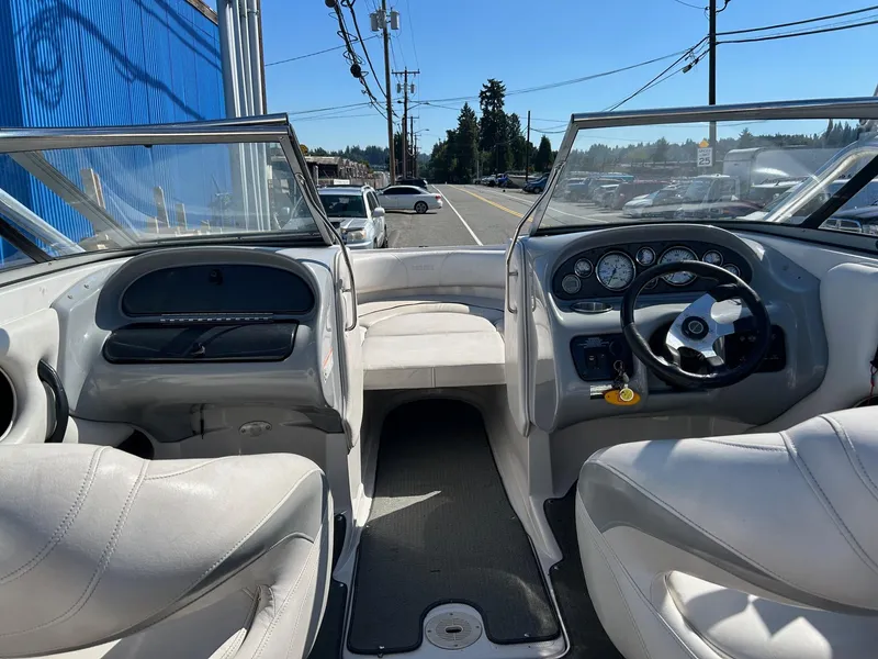 Slide: The Image of 2007 Reinell 220 LSE boat interior with steering wheel and seating, parked near a road. - 8