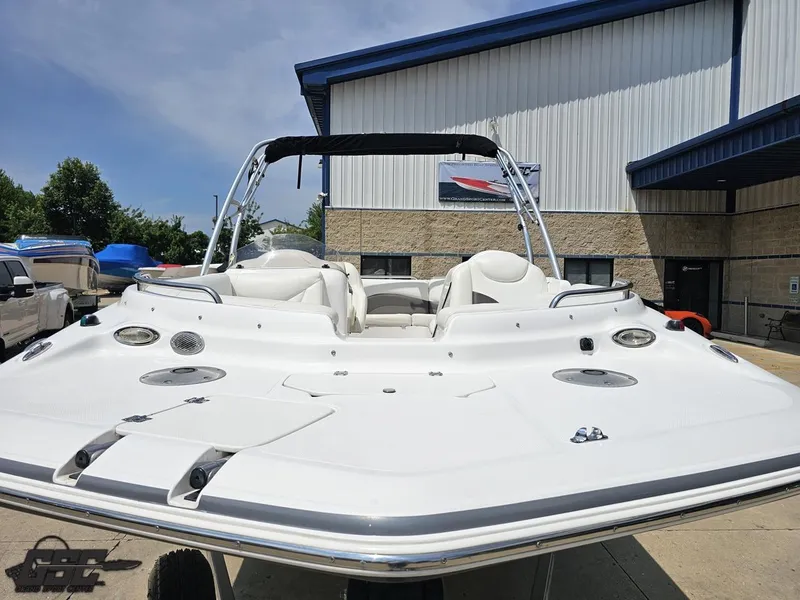 Slide: The Image of 2013 Hurricane SunDeck Sport 202 IO boat displayed outdoors near a building. - 14