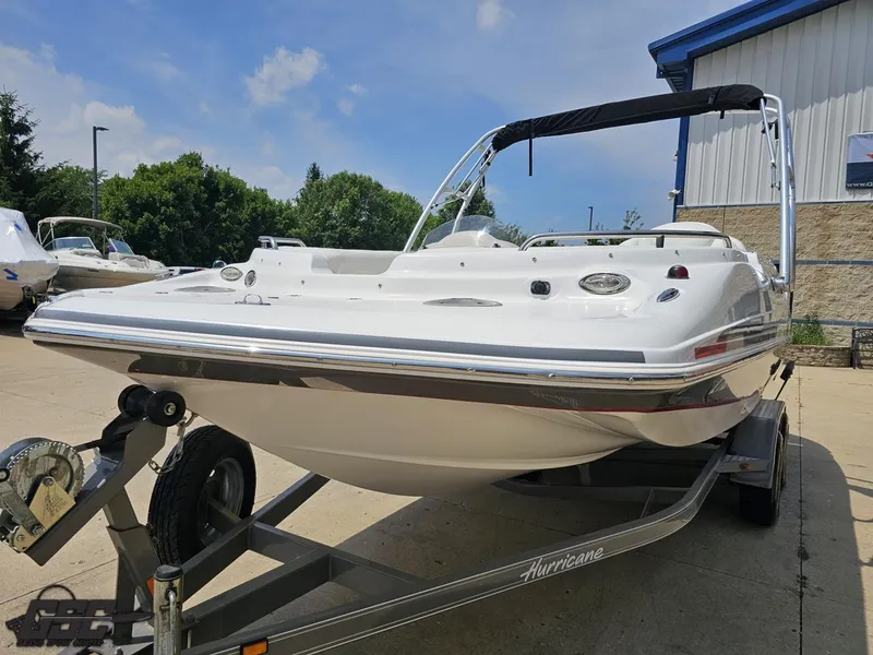 Slide: The Image of 2013 Hurricane SunDeck Sport 202 IO boat on trailer, parked outdoors. - 15