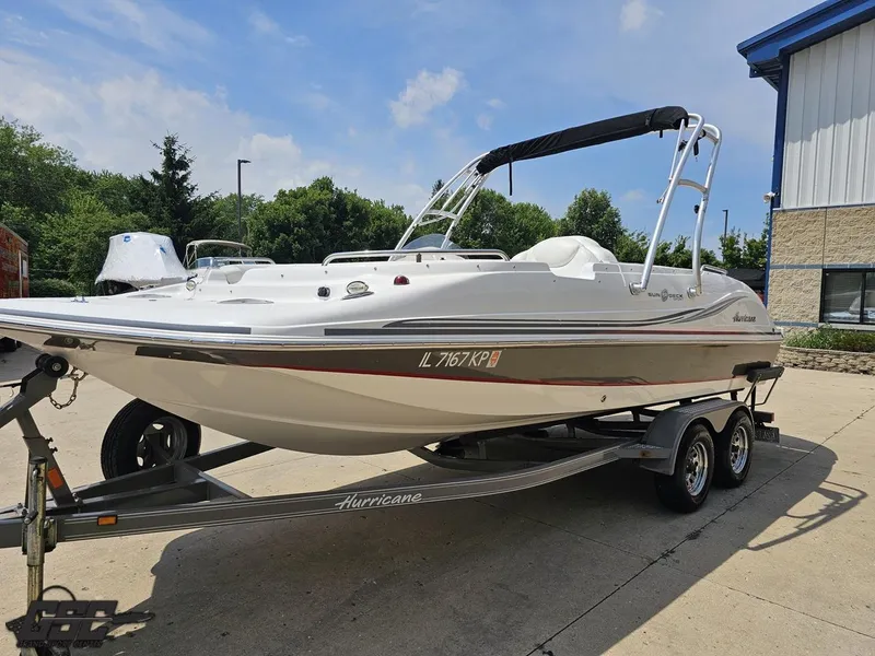 Slide: The Image of 2013 Hurricane SunDeck Sport 202 IO boat on trailer, parked outdoors. - 16