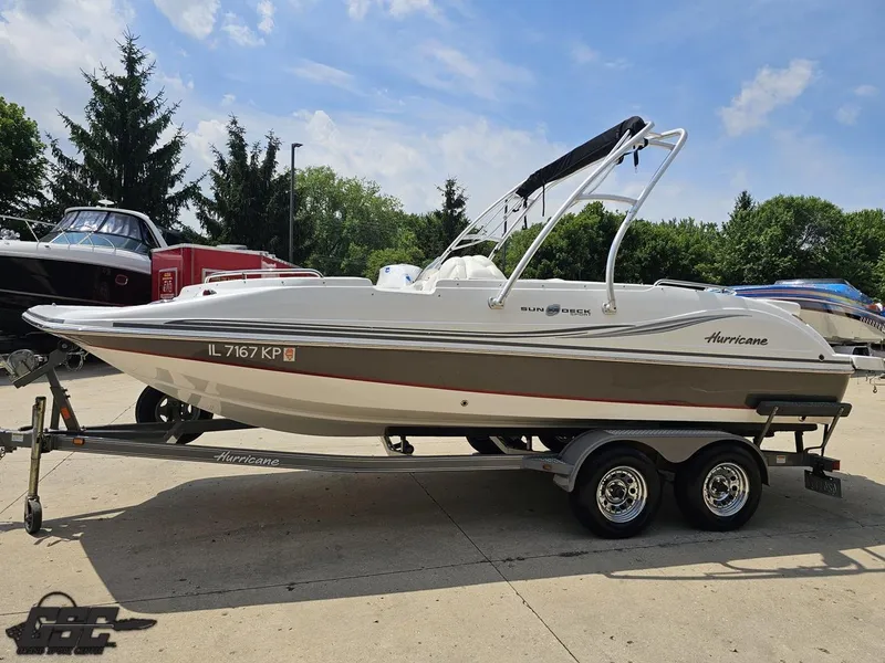 Slide: The Image of 2013 Hurricane SunDeck Sport 202 IO boat on trailer, parked outdoors. - 17