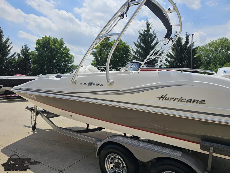 Slide: The Image of 2013 Hurricane SunDeck Sport 202 IO boat on trailer, sunny day, trees in background. - 24