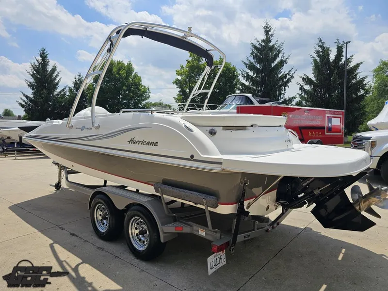 Slide: The Image of 2013 Hurricane SunDeck Sport 202 IO boat on trailer, parked outdoors. - 27