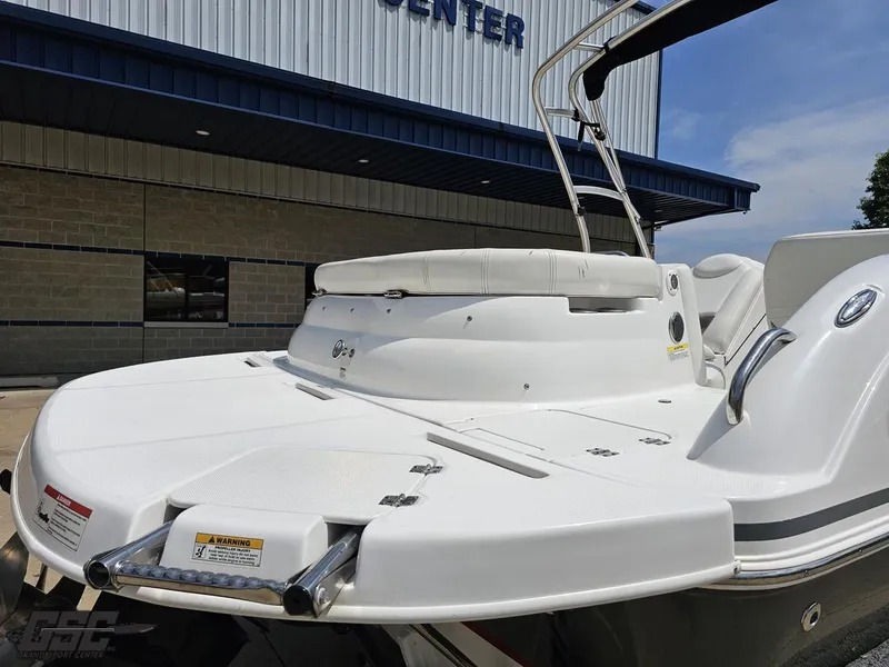 Slide: The Image of 2013 Hurricane SunDeck Sport 202 IO boat, white exterior, docked near a building. - 32