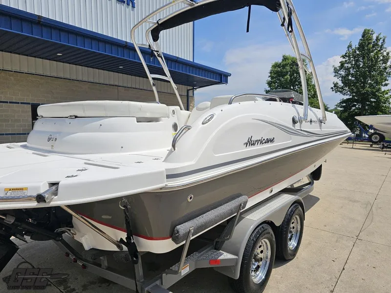 Slide: The Image of 2013 Hurricane SunDeck Sport 202 IO boat on trailer, parked outdoors. - 33