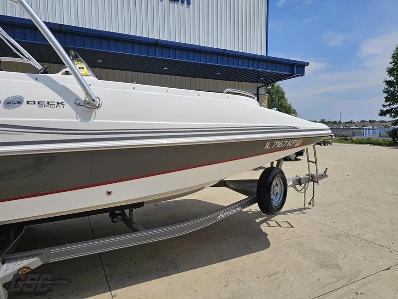 Slide: The Image of 2013 Hurricane SunDeck Sport 202 IO boat on trailer, parked outside a building. - 5