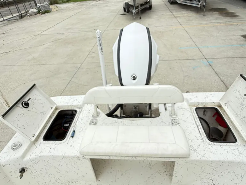 Slide: The Image of 2015 Blazer Bay 2400 boat with open storage compartments and outboard motor. - 18