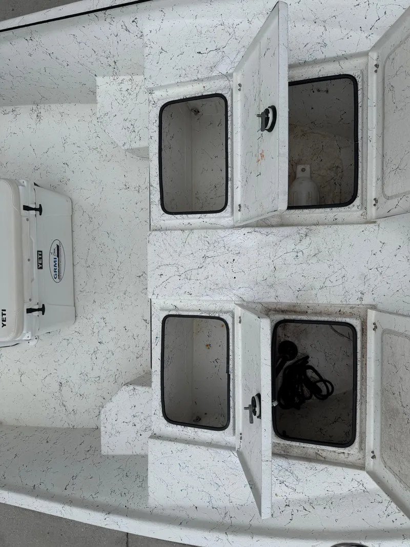 Slide: The Image of 2015 Blazer Bay 2400 boat interior with open storage compartments and a Yeti cooler. - 22