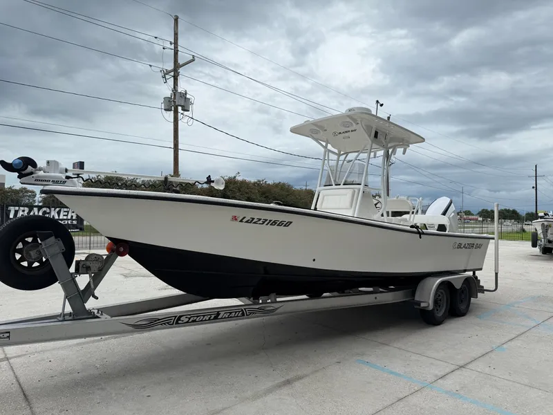 Slide: The Image of 2015 Blazer Bay 2400 boat on trailer under cloudy sky. - 3
