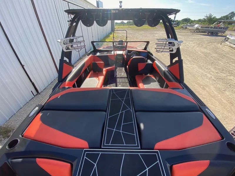 Slide: The Image of 2021 ATX Surf Boats 22 Type-S with red and black interior, docked outdoors. - 6