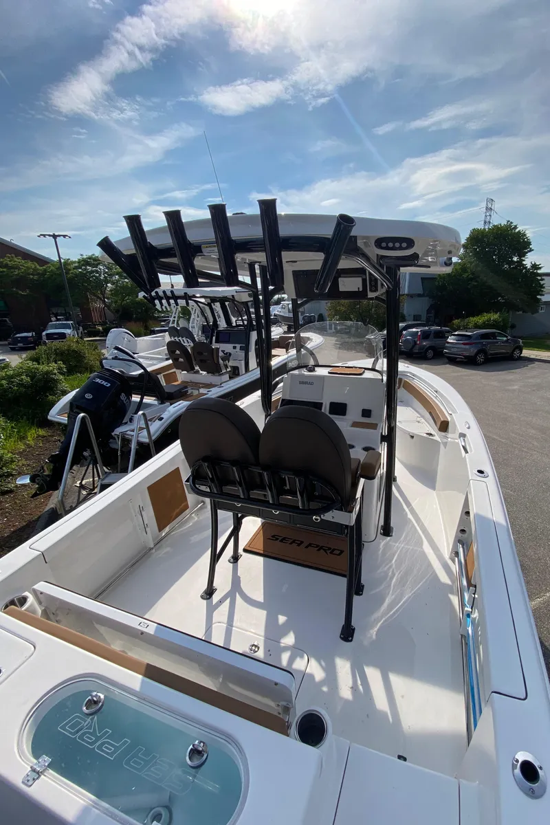 Slide: The Image of 2025 Sea Pro 222 Center Console boat with dual seats and rod holders, under a sunny sky. - 5