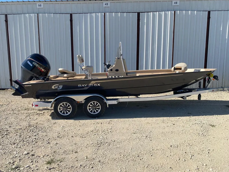 Slide: The Image of 2025 G3 Bay 21 GX boat on trailer, parked outdoors. - 0