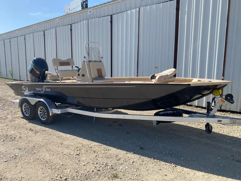 Slide: The Image of 2025 G3 Bay 21 GX boat on trailer, parked outdoors near metal building. - 1