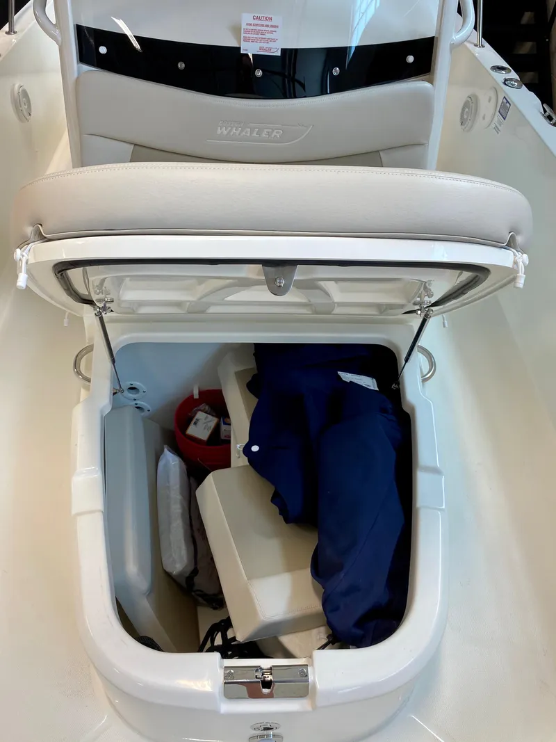 Slide: The Image of 2021 Boston Whaler 270 Dauntless storage compartment with safety gear and cushions. - 6