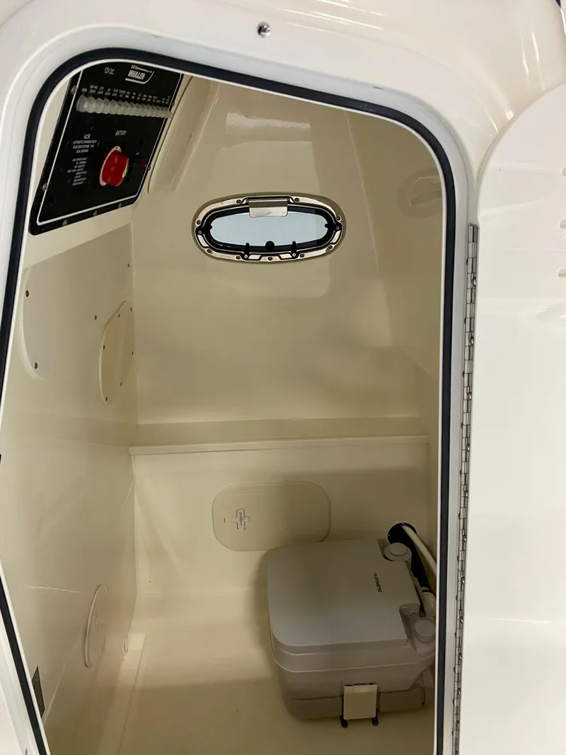 Slide: The Image of Interior of 2021 Boston Whaler 270 Dauntless boat with compact toilet and porthole. - 9