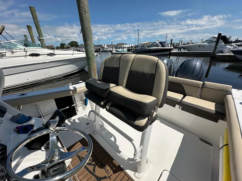 Slide: The Image of 2021 Tidewater 252 LXF boat interior with helm and seating at marina. - 10