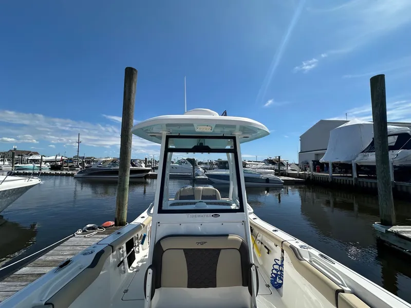 Slide: The Image of 2021 Tidewater 252 LXF boat docked at marina under clear blue sky. - 4
