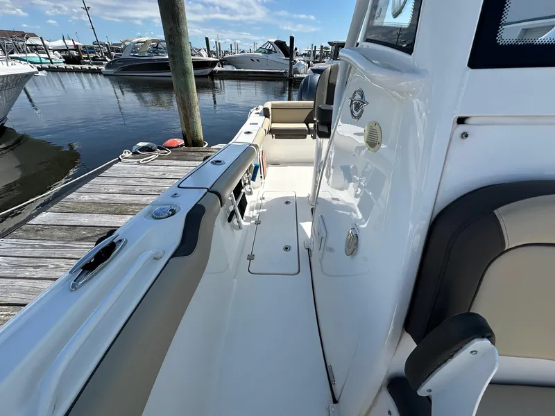 Slide: The Image of 2021 Tidewater 252 LXF boat docked at marina, showcasing sleek interior and seating. - 5