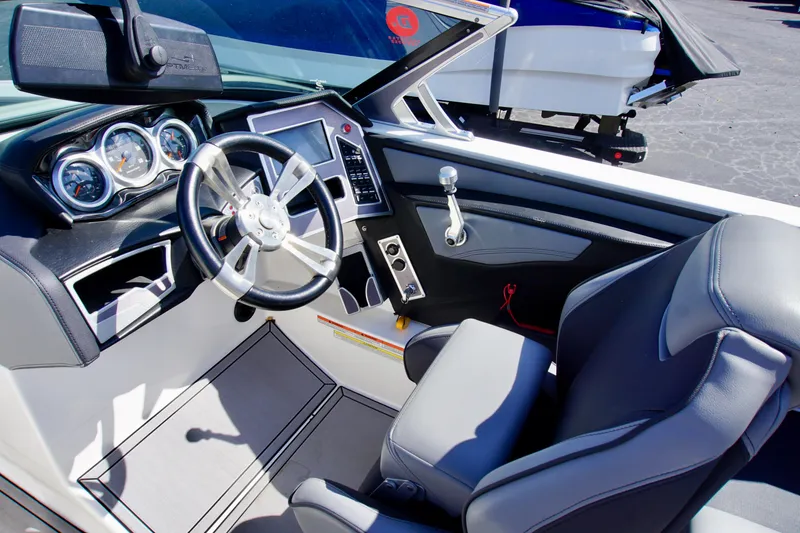 Slide: The Image of 2019 MasterCraft XT23 boat interior with steering wheel, dashboard, and seating. - 11