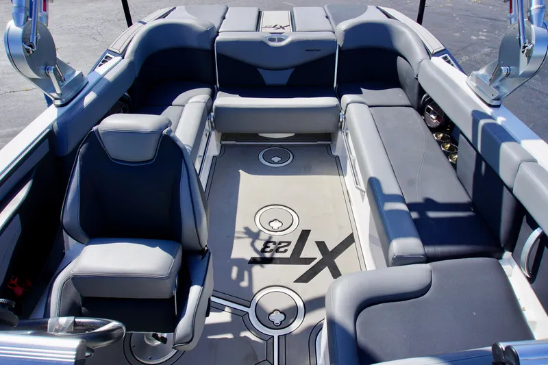 Slide: The Image of 2019 MasterCraft XT23 boat interior with gray seating and logo on the floor. - 7