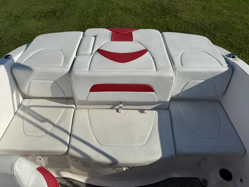 Slide: The Image of 2015 Chaparral 18 H2O Sport boat interior with white and red cushioned seating. - 10